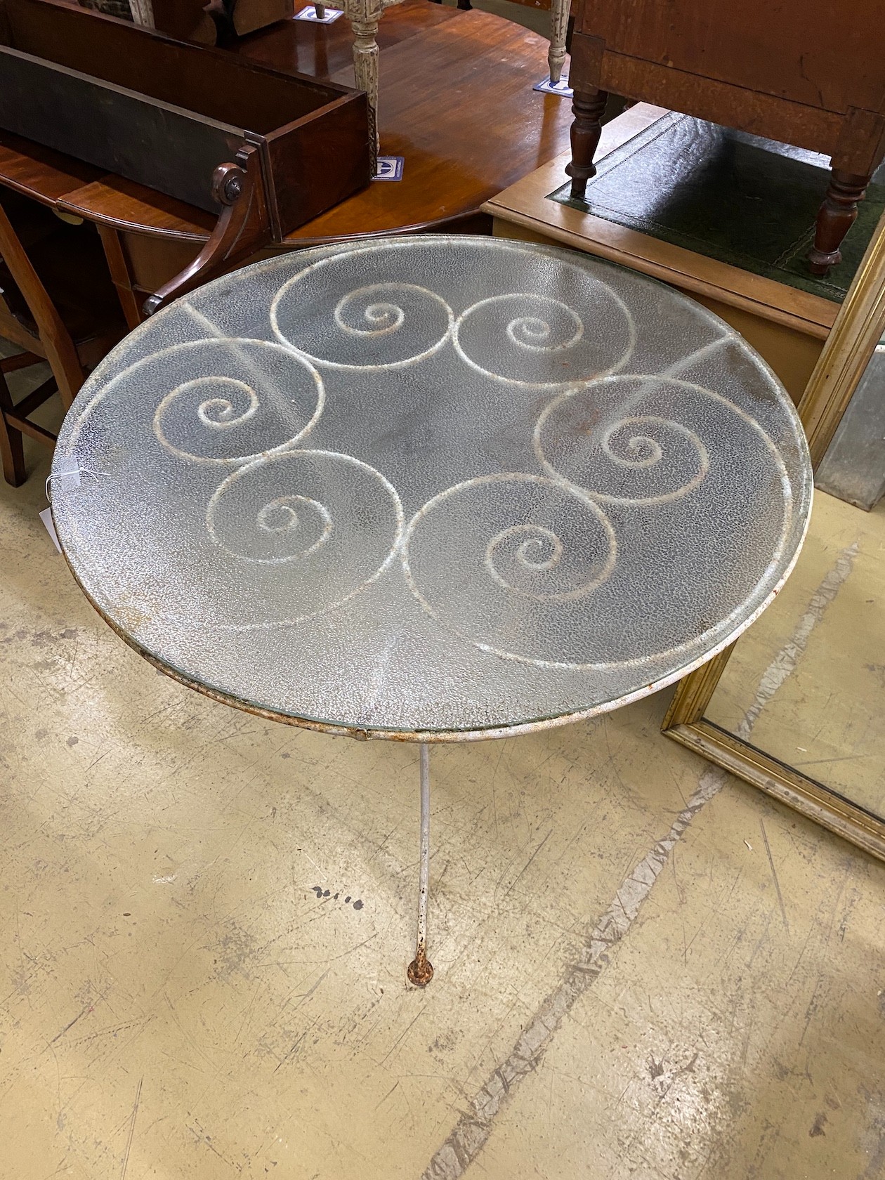A circular painted wrought iron glass top garden table, diameter 92cm, height 76cm.